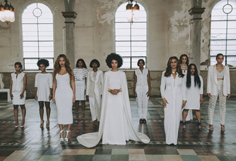 Solange Knowles decked out in a white gown with attached cape designed by Humberto Leon for Kenzo, posed alongside her bridal party in the New Orleans Museum of Art. 