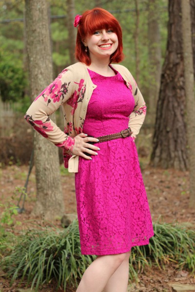 Model shows off her hot pink attire with floral cardigan, flower headband and belt.