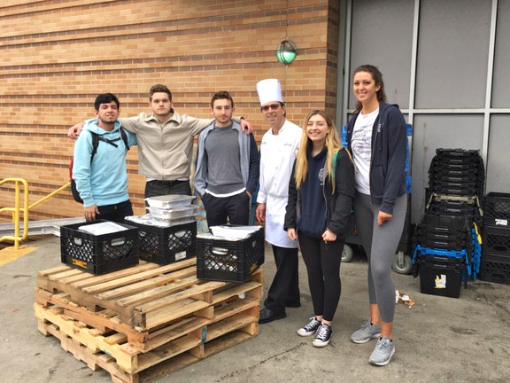 Student volunteers pose with Chef Kelly Heefner before taking donated food to local food pantry.