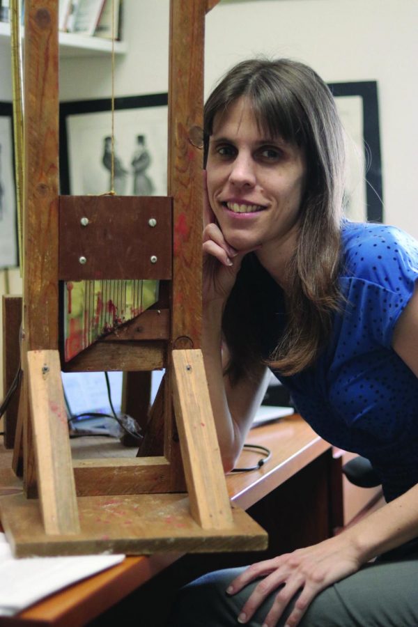 Dr. Erika Vause poses with her mini guillotine and speaks with the Torch about her history selections.